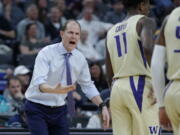 Washington head coach Mike Hopkins speaks with his players during the first half of an NCAA college basketball game against Colorado in the semifinals of the Pac-12 men’s tournament Friday, March 15, 2019, in Las Vegas.