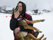 Nicolas Petit hugs one of his dogs before they leave Unalakleet, Alaska, during the Iditarod Trail Sled Dog Race on Sunday, March 10, 2019.