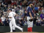 Boston Red Sox starting pitcher Eduardo Rodriguez, right, looks away as Seattle Mariners’ Jay Bruce rounds the bases behind on his three-run home run in the fifth inning of a baseball game Saturday, March 30, 2019, in Seattle.