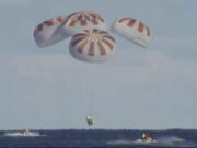 This image provided by NASA shows SpaceX’s Dragon capsule carrying a test dummy splashed down into the Atlantic ocean off the Florida coast, Friday, March 8, 2019. It marks the first time in 50 years that a capsule designed for astronauts returned from space by plopping into the Atlantic.