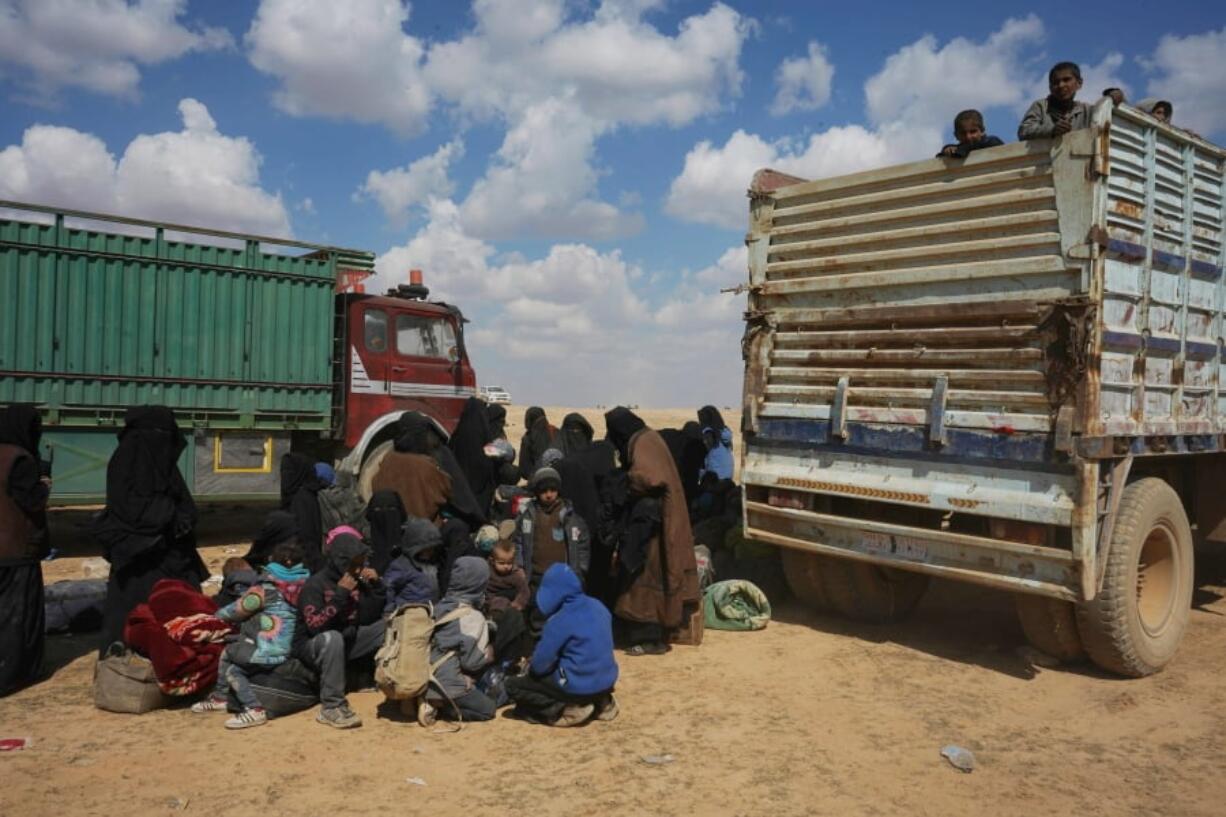 Women and children gather near trucks Wednesday outside Baghouz, Syria, after being evacuated from territory held by Islamic State militants.