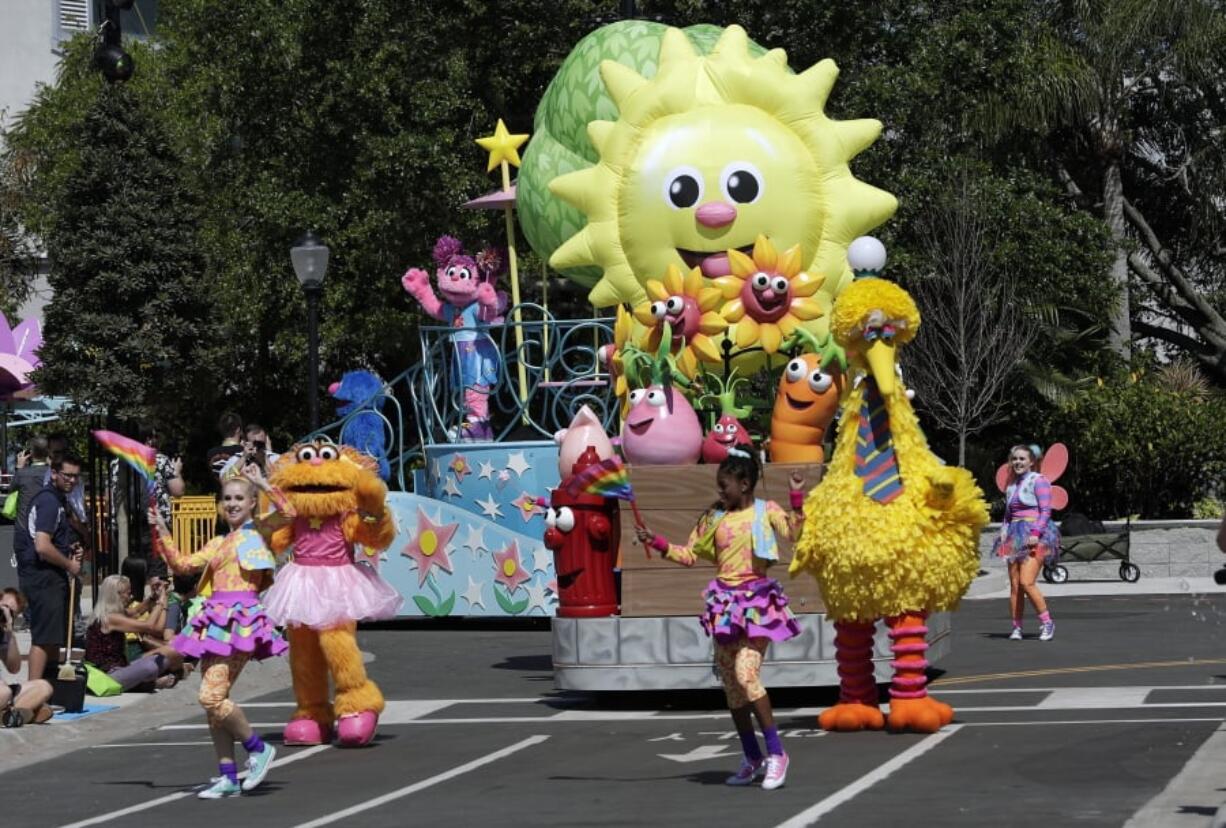 In this Tuesday, March 26, 2019 photo, floats, performers and characters including Big Bird take part in a parade during a preview day at SeaWorld Orlando opening of Sesame Street land in Orlando, Fla., an addition to central Florida’s theme park landscape aimed at young families.