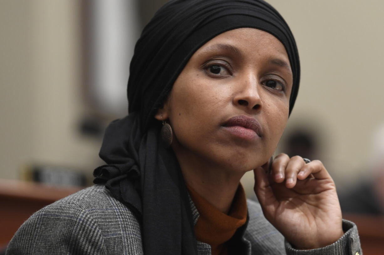 In this March 12, 2019, photo, Rep. Ilhan Omar, D-Minn., listens as Office of Management and Budget Acting Director Russ Vought testifies before the House Budget Committee on Capitol Hill in Washington.