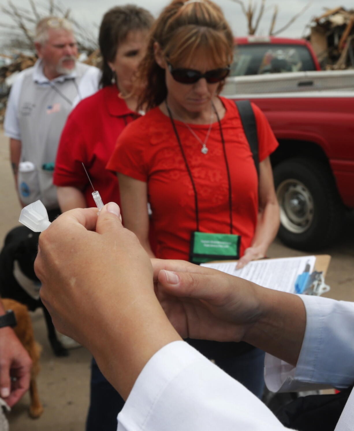 FILE - In this May 27, 2013 file photo a needle with tetanus vaccine is prepared by a nurse practitioner on a tornado ravaged street in Moore, Okla. An unvaccinated 6-year-old Oregon boy was hospitalized for two months for tetanus and almost died of the bacterial illness after getting a deep laceration on his forehead while playing on a farm, according to a case study published Friday, March 8, 2019 by the U.S. Centers for Disease Control and Prevention.