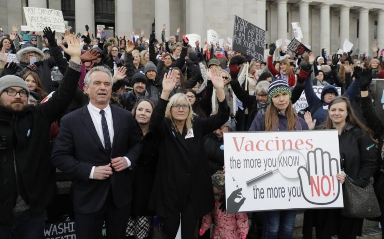 FILE- In this Feb. 8, 2019, file photo, Robert Kennedy Jr., left, stands with participants at a rally held in opposition to a proposed bill that would remove parents’ ability to claim a philosophical exemption to opt their school-age children out of the combined measles, mumps and rubella vaccine, at the Capitol in Olympia, Wash. Hundreds of parents in Oregon came to oppose a proposal to tighten vaccination requirements among schoolchildren. The move comes as a Washington community just over the Oregon border works to contain a measles outbreak that’s sickened more than 65 people. (AP Photo/Ted S.