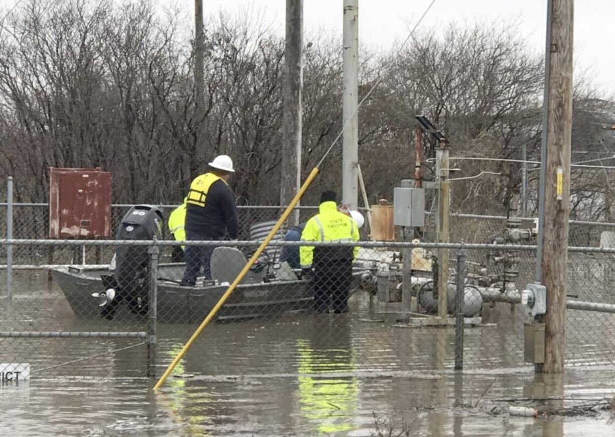 In this Wednesday, March 20, 2019 photo provided by the Missouri State Highway Patrol shows Water Patrol Troopers assisting utility company employees in shutting off natural gas lines in flood waters at Craig, Mo. In northwest Missouri, a levee breached Tuesday, unleashed a torrent that overwhelmed a temporary berm that was built up with excavators and sandbags to protect the small town of Craig, where the 220 residents have been ordered to evacuate. “They’ve got water running down Main Street,” said Tom Bullock, emergency management director of Holt County, where Craig is located.