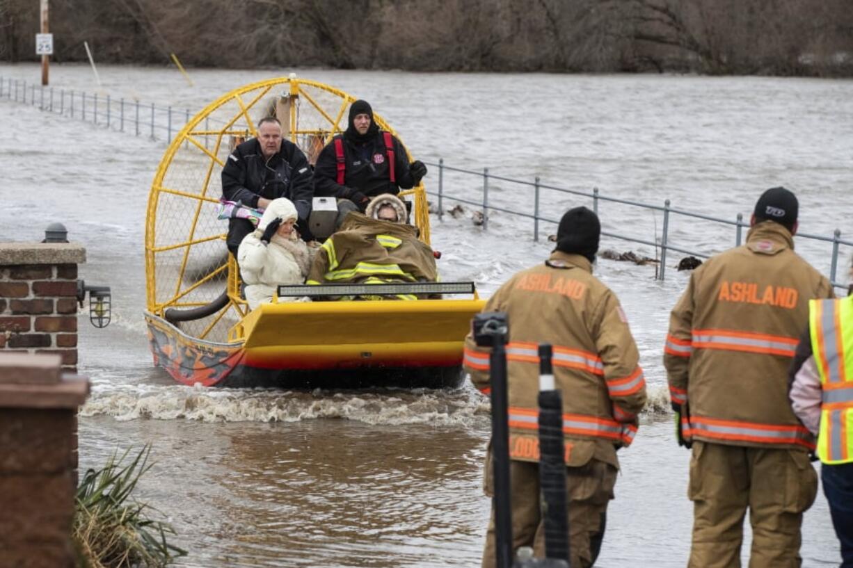 Mary Roncka and her husband Gene Roncka, right, accompanied by neighbor Kevin Mandina are evacuated as floodwaters rise Thursday, March 13, 2019, in Ashland, Neb. Evacuations forced by flooding have occurred in several eastern Nebraska communities, as western Nebraska residents struggled with blizzardlike conditions.