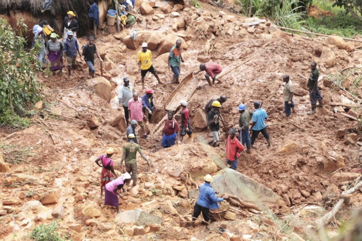 A family dig for their son who got buried in the mud when Cyclone Idai struck in Chimanimani about 600 kilometres south east of Harare, Zimbabwe, Tuesday, March, 19, 2019. According to the government, Cyclone Idai has killed more than 100 people in Chipinge and Chimanimani and according to residents the figures could be higher because the hardest hit areas are still inaccessible.