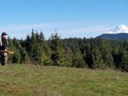 Buzz Ramsey of Lyle, Washington scans the hillsides for wild turkeys recently with a snow-capped Mount Adams in the distance. The spring hunting season for turkeys began last Monday under sunny skies, and will run until May 31.