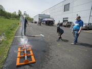 Rosalynn Bussiere, 11, in hoodie, takes her rocket filled with water for a test run while joined by her father, program manager Ron Bussiere, in blue, during Take Your Child To Work Day at Sigma Design in Camas on Thursday afternoon, April 25, 2019. The kids were challenged to build a rocket that could hold a cookie and keep it safe from launch through landing. In addition, participants in the event got a chance to learn how an idea goes from concept to production as well as play with trebuchet cookie catapults among other activities.