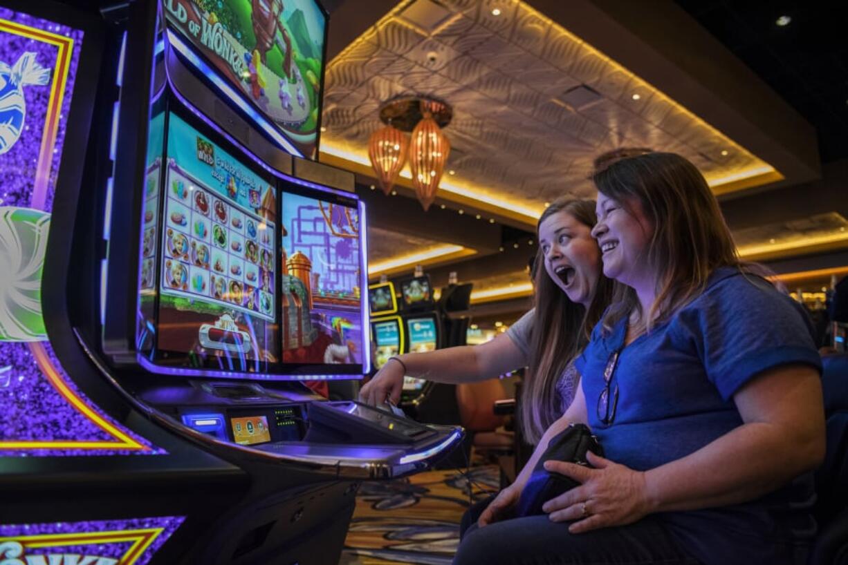 Alisha Alexander, left, and her mother, Lisa Lugar, right, both of Ridgefield, play the new Willy Wonka World of Wonka slot machine at ilani. Lugar said she and her daughter have come to enjoy “Forever Young Mondays,” where guests 50 years and older receive special perks. Wednesday marks ilani’s two-year anniversary.