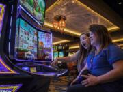 Alisha Alexander, left, and her mother, Lisa Lugar, right, both of Ridgefield, play the new Willy Wonka World of Wonka slot machine at ilani. Lugar said she and her daughter have come to enjoy “Forever Young Mondays,” where guests 50 years and older receive special perks. Wednesday marks ilani’s two-year anniversary.