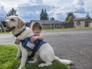 Jack Keller, 3, hugs his diabetic service dog Max in front of his home in Kalama. Max will paw Jack’s parents to alert them if Jack’s blood sugar enters dangerous territory.