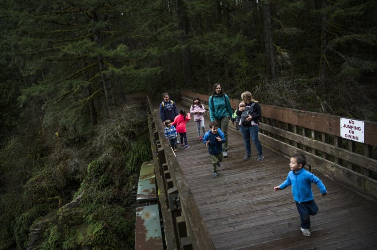 Shannon Steeves of Vancouver, center, walks across the bridge at Moulton Falls Regional Park last week with her friends and their children. Clark County opted not to install fencing on the bridge after video of Jordan Holgerson of Kalama being pushed off went viral in August 2018.