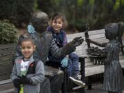 Kingston Cason, 4, foreground, of the Boys & Girls Clubs of Southwest Washington's Hope Team enjoys some down time at Esther Short Park with Kimiyo Tubania, 7, late Tuesday morning. The pair were among 20 local volunteers from the Hope Team who came out to clean rubbish from the downtown Vancouver park.