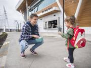 Ben Coulimore, left, of Vancouver offers fried calamari to his sister, Ally Coulimore, 2, after the two bought lunch Tuesday from The Daily Catch. The walk-up restaurant — part of WildFin American Grill — opened Monday.