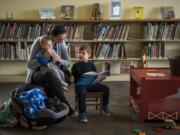 Katie Didyk of Battle Ground holds her son Benny, 9 months, and reads with her son Artem, 4, at the Battle Ground Community Library, which will close for three weeks starting Monday for upgrades, one of which is rearranging furniture to make the children’s area more comfortable for families. While Battle Ground will have some minor upgrades, Fort Vancouver Regional Libraries is also in the process of trying to build four new buildings to increase services around the county.