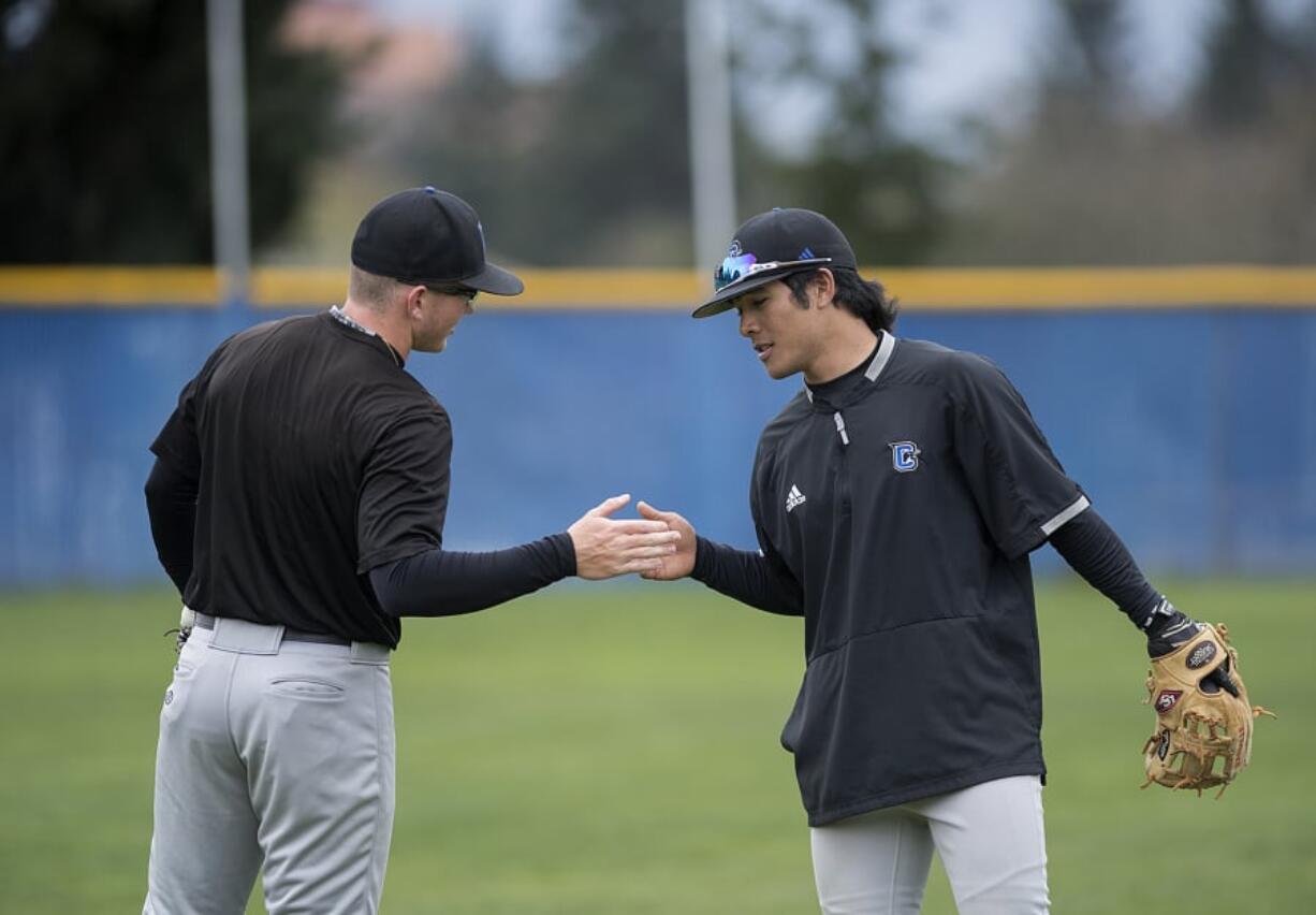 Teammates Connor Wojahn, left, and Kai Perreira of Clark College, facing, encourage each other during practice at Kindsfather Field.