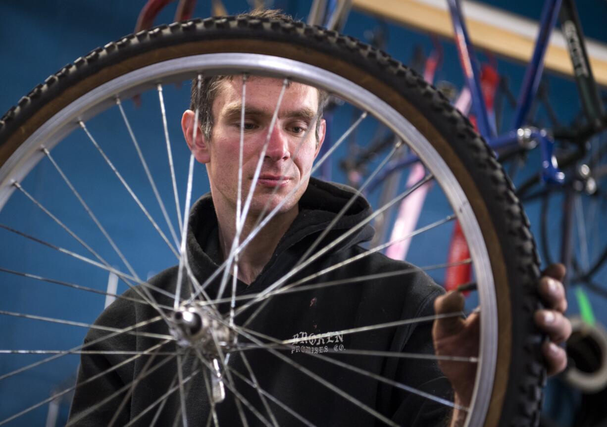 Kelly Childress of Vancouver changes out his tires at Bike Clark County's Community Hub bike shop on Main St. in Vancouver on Thursday afternoon, April 4, 2019. The non-profit opened up shop in Uptown Village about two years ago, but the organization has been running for about eight years. The shop offers a work station for the community to use. Childress said he stops by the shop often to work on his bike or check out new and used parts. "It has everything you need," he said.