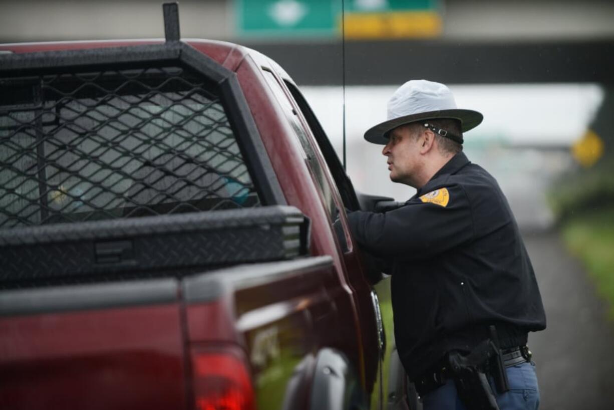 Washington State Patrol Trooper Jeffrey Heath gives a citation to a driver for talking on the phone while driving north Sunday on Interstate 5 near Mill Plain Boulevard.