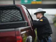 Washington State Patrol Trooper Jeffrey Heath gives a citation to a driver for talking on the phone while driving north Sunday on Interstate 5 near Mill Plain Boulevard.