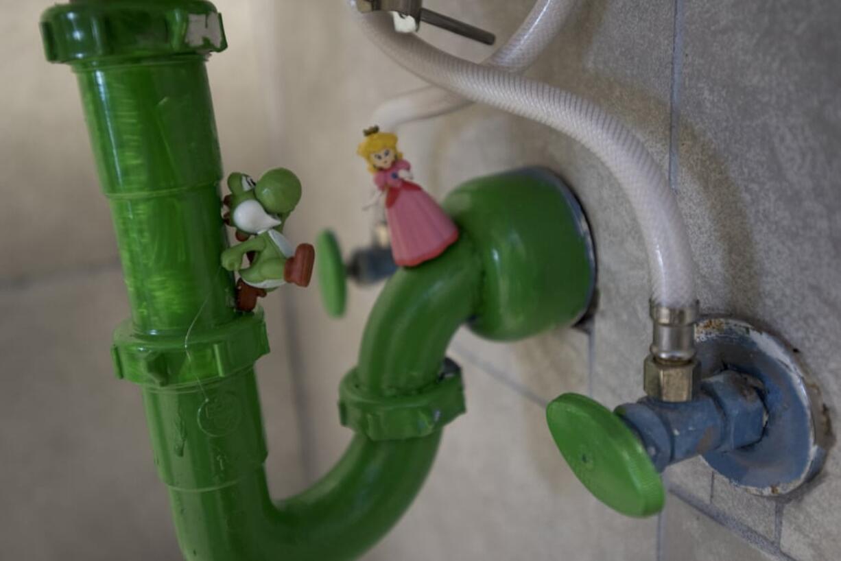 Super Mario video game characters are seen on the sink pipes in a bathroom at Vault 31.