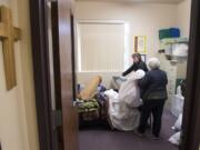 Battle Ground Community United Methodist Church Pastor Susan Boegli, left, and Jean Brown prepare a bedroom for guests arriving Wednesday night. The church is taking a turn hosting Family Promise of Clark County, a new shelter that rotates to a different congregation each week. “Sunday when people come to church this will all be put away,” Brown said.