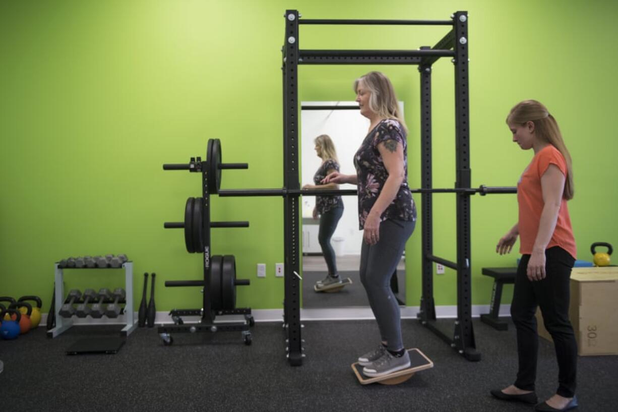 Cheryl Carroll of Vancouver performs a strengthening exercise while physical therapist Adria Biasi supervises at the Vancouver Therapydia, a physical therapy and wellness clinic that specializes in one-on-one appointments. “I get to be with them through the manual therapy, through the exercises, watching every move that they are making and correcting through that,” Biasi said of clients.