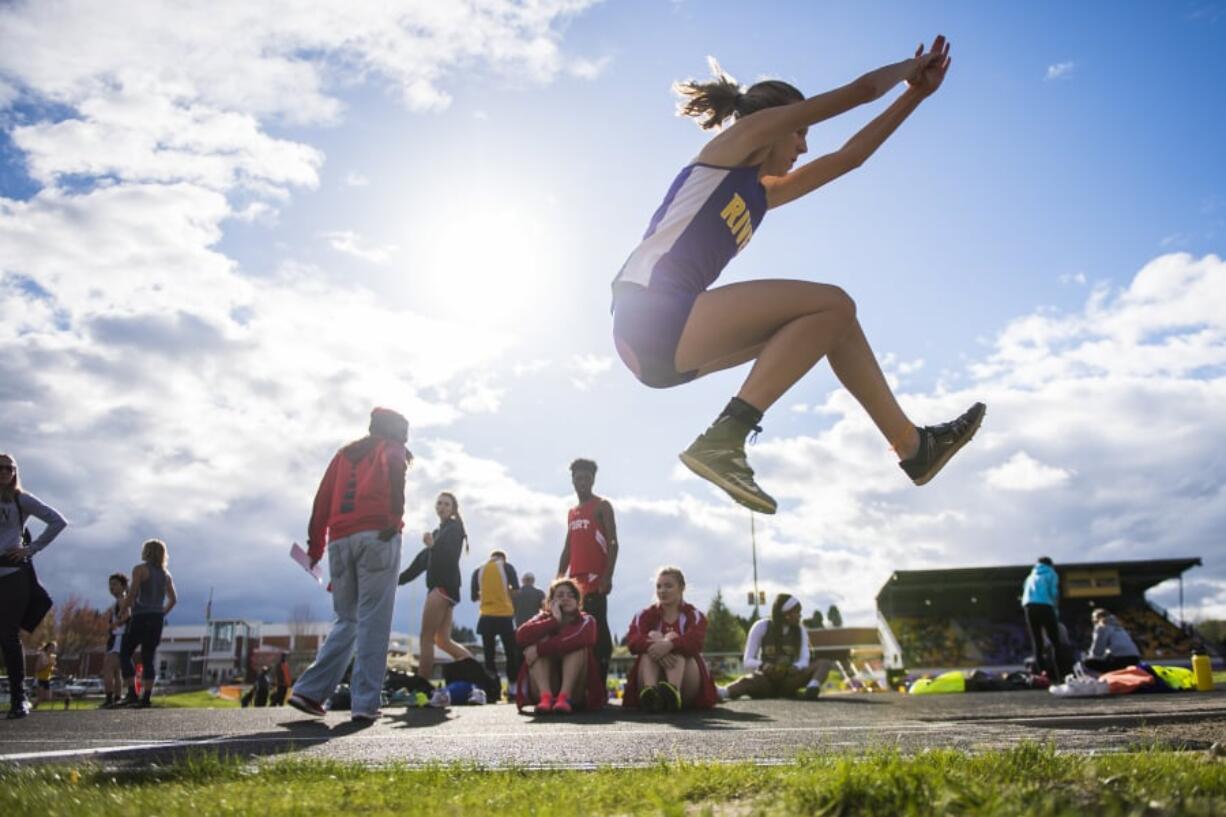 Columbia River’s Giovanna Rhoads completes the triple jump during the John Ingram Twilight Track Meet at Columbia River High School on Friday night, April 12, 2019.