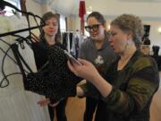 From left, Devaki Chapel, Heidi Blackwelder and Alisa Tetreault eye a piece of clothing Sunday at the Couve Couture marketplace at the Red Cross Building in Vancouver.