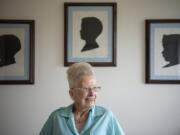 Camas historian Virginia Warren, 94, sits on her bed below three silhouettes she traced and cut out of her sons more than 50 years ago. She recently donated three scrapbooks she compiled of local history to the Camas Public Library.