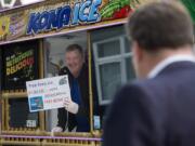 Steve McCulloch of Kona Ice greets pedestrians with a smile as he offers a free shave ice to those passing by the downtown post office Monday afternoon. The event was part of national “Chill Out Day” for those stressed out due to the annual Tax Day deadline.