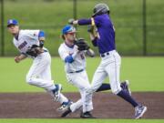 Columbia River's Parker McNeil tries and fails to dodge a tag from Ridgefield's Jimmy Wallace during a game at the Ridgefield Outdoor Recreation Center on Tuesday night, April 16, 2019.