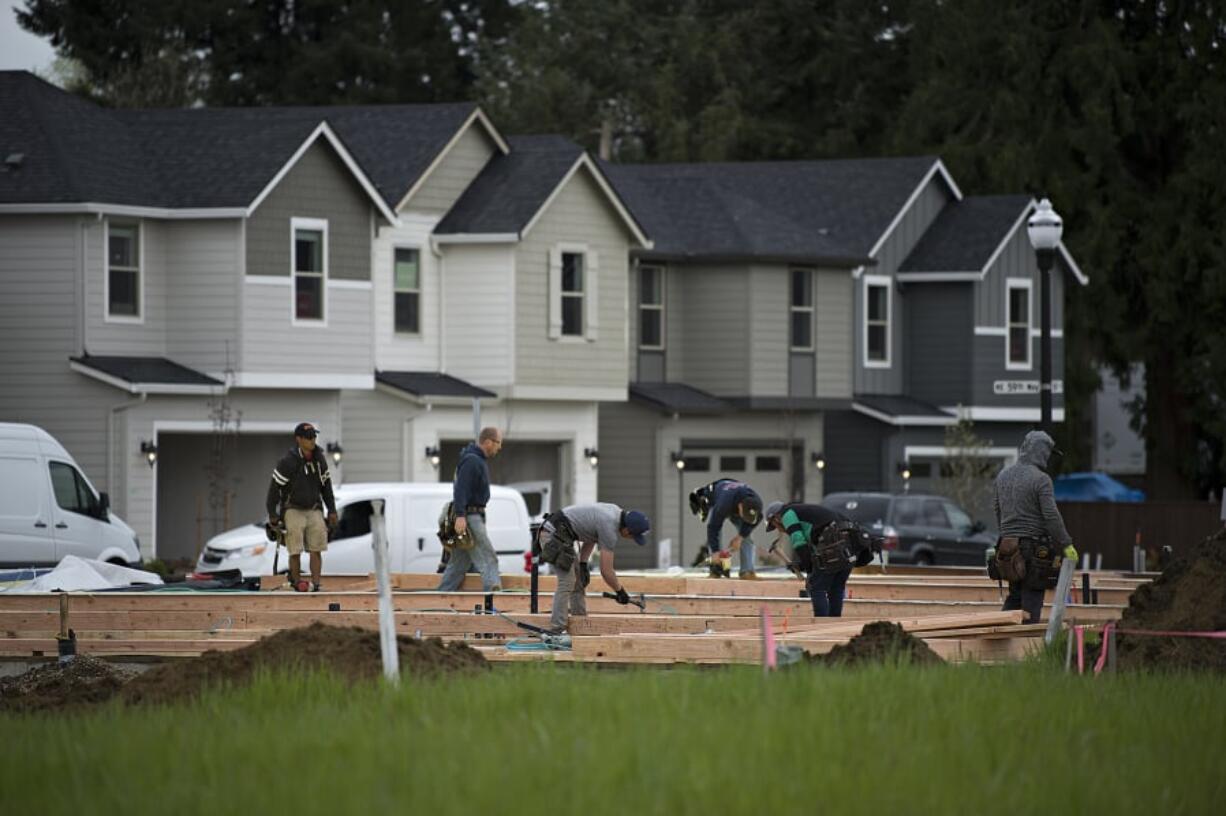 Homes at various stages of construction are seen at Meadows at 58th Street in the Minnehaha area as workers lend a hand to the project Wednesday morning.