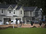 Homes at various stages of construction are seen at Meadows at 58th Street in the Minnehaha area as workers lend a hand to the project Wednesday morning.