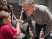 Theron Roberts, 4, holds up fingers to show the Rev. David Whiting how old he is as Whiting introduces himself to attendees at a Good Friday service at the New Heights Church North Campus in Battle Ground.