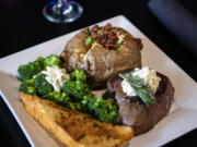 The top sirloin steak with a loaded baked potato and a side of broccoli and garlic bread at Billy Blues Bar and Grill.