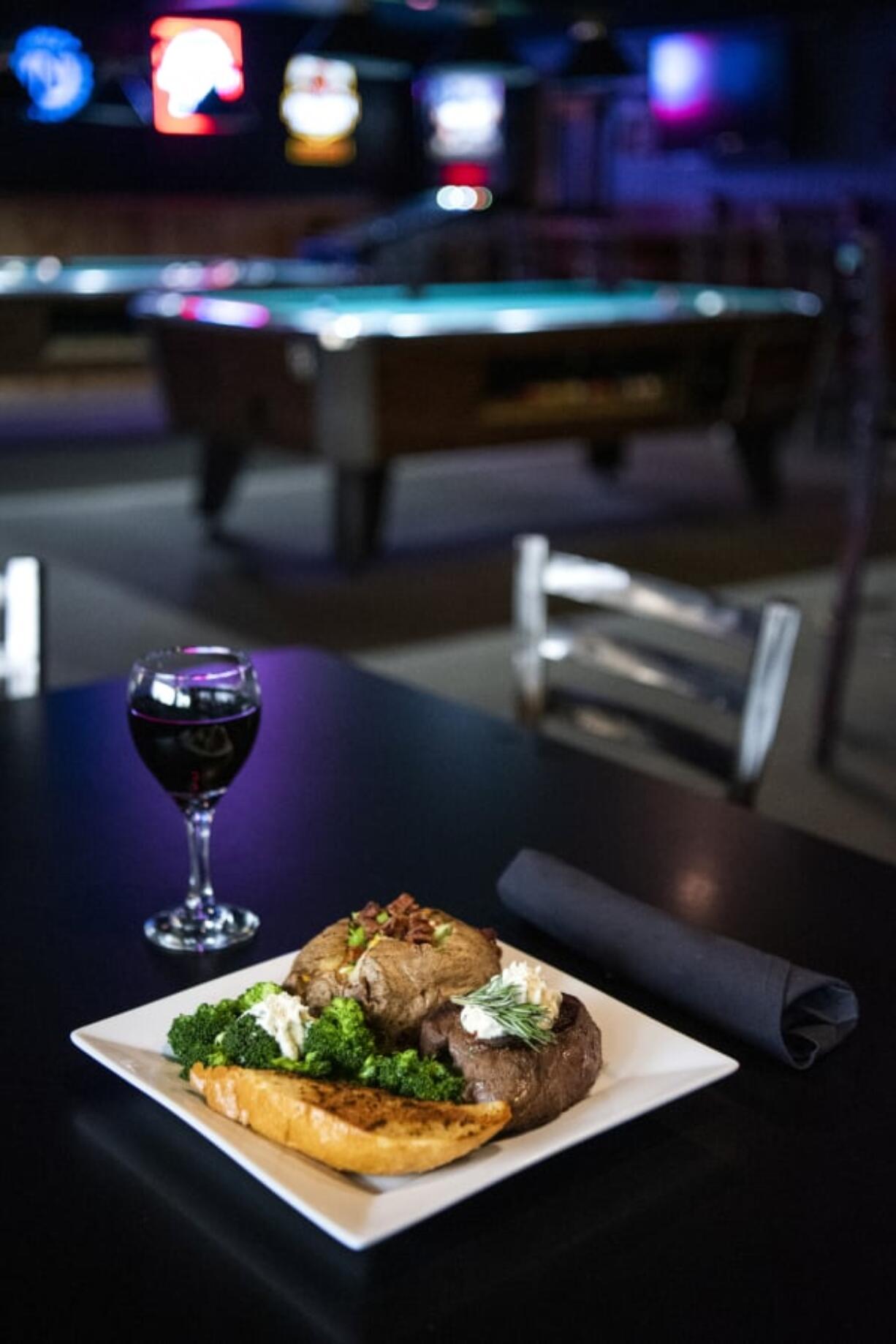 The top sirloin steak with a loaded baked potato and a side of broccoli and garlic bread at Billy Blues Bar and Grill.