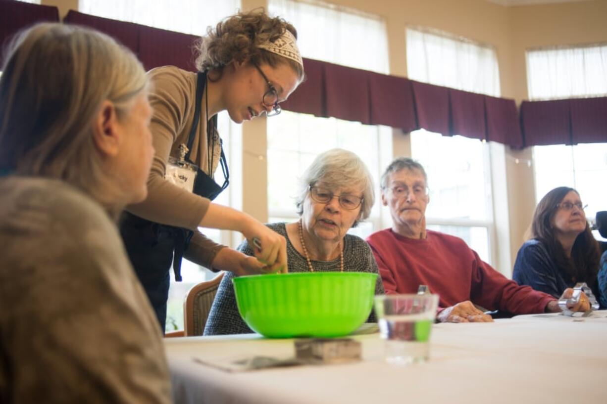 Eldergrow educator Becky Plourde helps resident Fay Holbrook make a bird feeder during an Eldergrow class at Touchmark at Fairway Village in Vancouver. Eldergrow is a program that offers therapeutic gardening services and equipment inside senior living facilities.