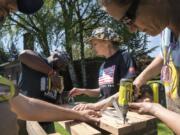 Joshua Franklin, left, Kwame Bey, Tess Acosta, and Debbie Debozy construct a wash and pack station as part of the Boots 2 Roots PDX program on the Vancouver VA Campus.