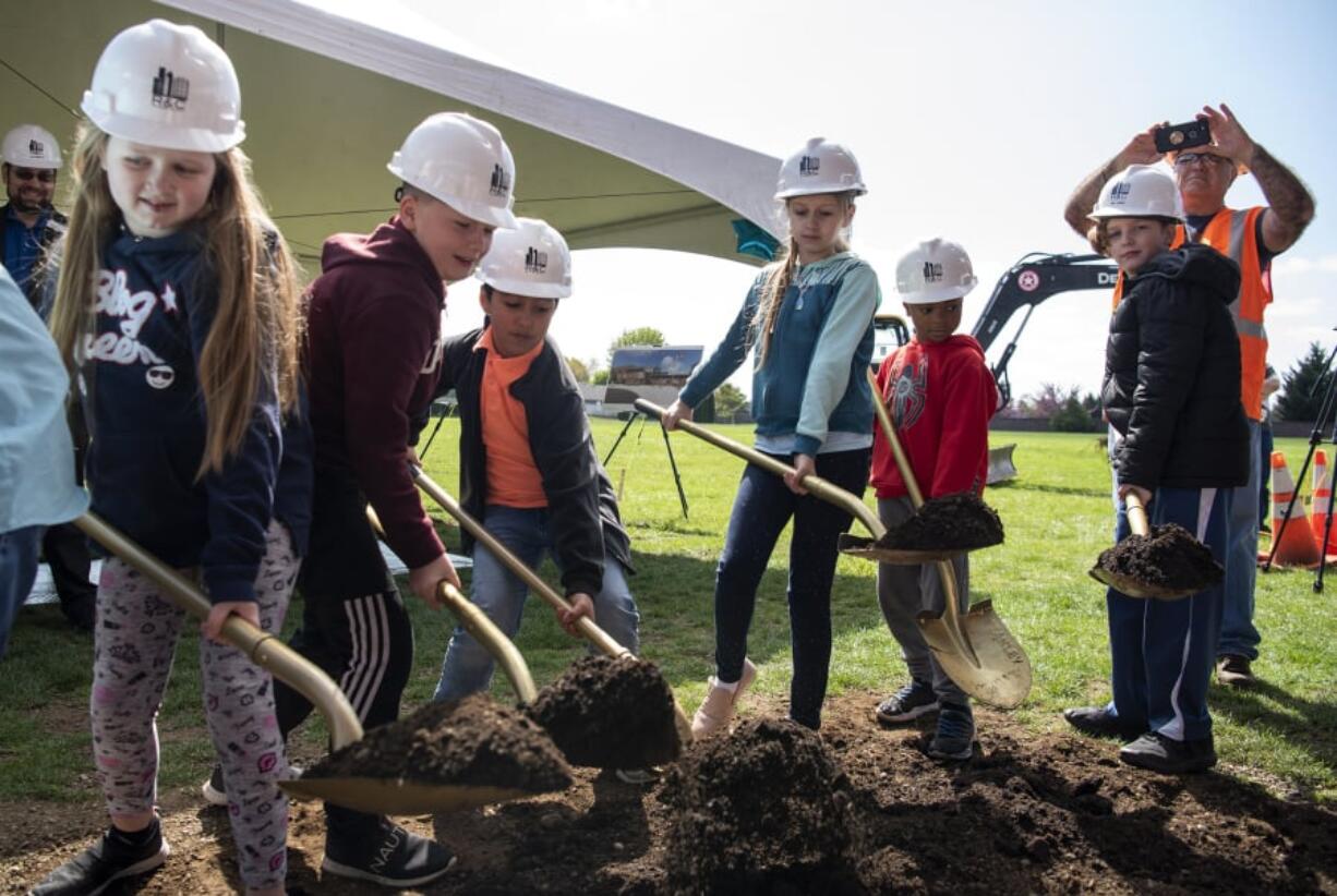 Students from Sifton Elementary School break ground Wednesday on the site of a future elementary school campus during a school assembly in Vancouver.