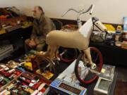 Terry Parker, 69, of Portland, sits near his vintage tricycle Sunday at the Vancouver Toy Junkies Vintage Toy Show and Sale. Below, a prop E.T., the Extra-Terrestrial, sits on display Sunday at the Vancouver Toy Junkies Vintage Toy Show and Sale.