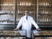 Dennis Epstein, owner of Apogee Culinary Designs, stands in the gallery at his new Hazel Dell knife store. The store sells several brands of kitchen and pocket knives, as well as a selection of restored and refinished knives that customers have traded.