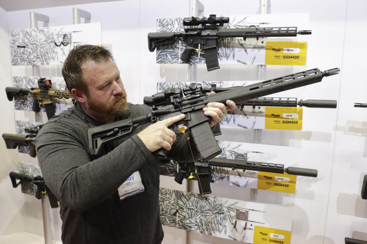 Bryan Oberc, Munster, Ind., tries out an AR-15 from Sig Sauer in the exhibition hall at the National Rifle Association Annual Meeting in Indianapolis, Saturday, April 27, 2019.