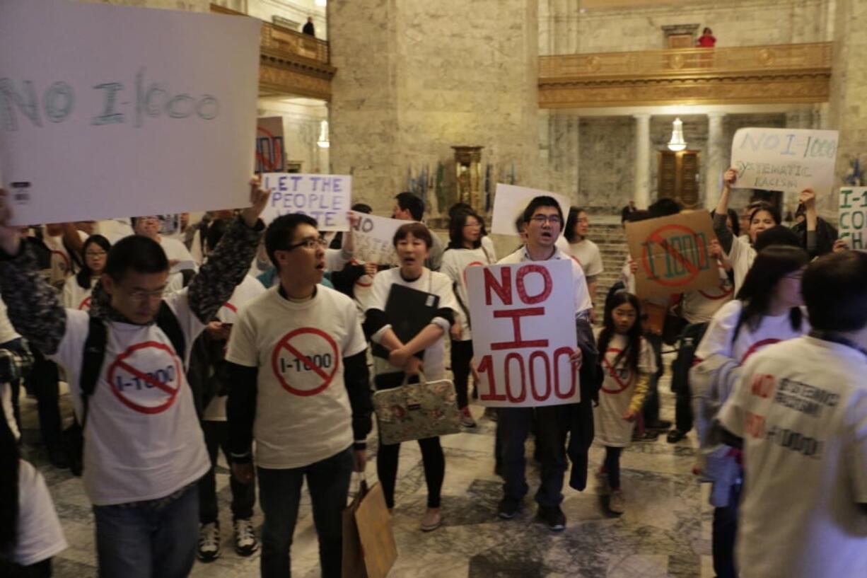 Opponents of an initiative to the Legislature that would allow the state to use hiring and recruitment goals, but not quotas, to bring minority candidates into state jobs, education and contracting march and chant “Shame on you!” outside the Senate chambers after the Senate passed the measure, Sunday, April 28, 2019, in Olympia, Wash. The measure loosens restrictions enacted in a separate 1998 initiative that banned government discrimination or preferential treatment based on factors like race or gender.