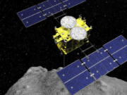 In this computer graphics image released by the Japan Aerospace Exploration Agency (JAXA), the Hayabusa2 spacecraft is seen above on the asteroid Ryugu. Japan's space agency JAXA said Friday, April 5, 2019, its Hayabusa2 spacecraft released an explosive onto an asteroid to make a crater on its surface and collect underground samples to find possible clues to the origin of the solar system. The mission is the riskiest for Hayabusa2, as it has to immediately get away so it won't get hit by flying shards from the blast.