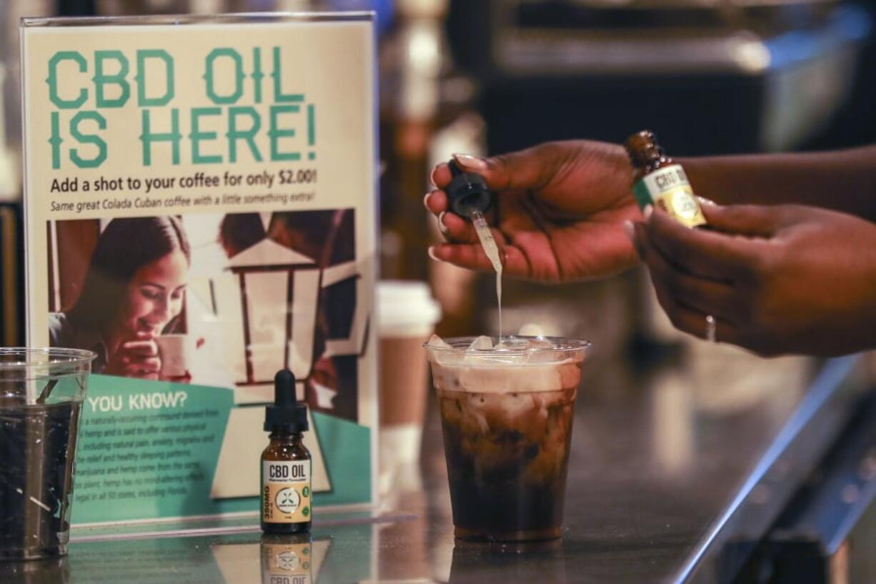 FILE - In this Friday, Jan. 4, 2018 file photo, a worker adds CBD oil to a drink at a coffee shot in Fort Lauderdale, Fla. Cannabidiol is one of more than 100 compounds found in marijuana.