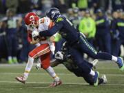 FILE - In this Dec. 23, 2018, file photo, Kansas City Chiefs quarterback Patrick Mahomes (15) is tackled by Seattle Seahawks defensive end Frank Clark, right, during the second half of an NFL football game, in Seattle. The Kansas City Chiefs have agreed to acquire defensive end Frank Clark from the Seattle Seahawks in exchange for a first-round draft pick this year and a second-round pick in 2020. Almost immediately after word leaked of the trade on Tuesday, April 23, 2019, Clark and the Chiefs worked quickly to reach agreement on a five-year contract worth up to $105 million, according to a person with knowledge of the deal. The person spoke to The Associated Press on the condition of anonymity because the deal had not been announced by either team and was still pending a physical.