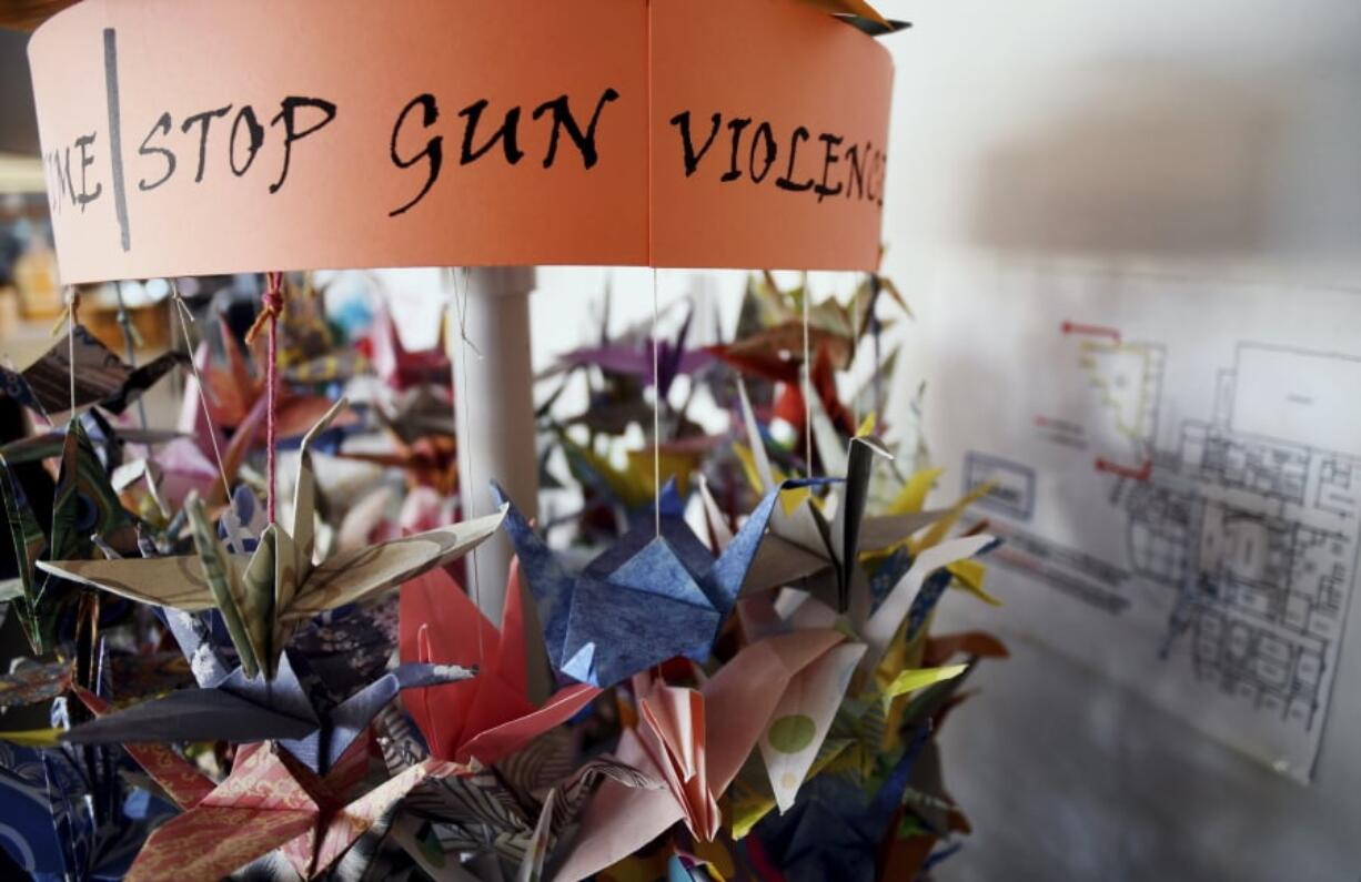 FILE - In this March 23, 2019, file photo, origami cranes, a symbol of peace, hang in the Columbine High School library in Littleton, Colo., near where several survivors and family members of the victims gathered to speak about the upcoming 20th anniversary of the April 20, 1999, shooting. In the two decades since the Columbine High School massacre, therapists still struggle with how to help people cope.