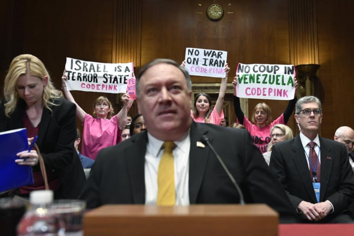 Protesters stand up as Secretary of State Mike Pompeo sits down to testify before the Senate Appropriations subcommittee on Capitol Hill in Washington, Tuesday, April 9, 2019, about the FY’20 budget.